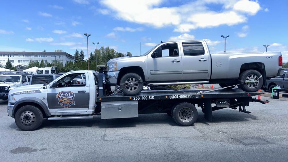 KZAM flatbed hauling a pickup
